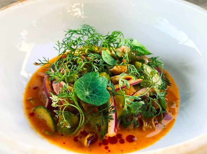 A bowl of shrimp and greens in a light broth