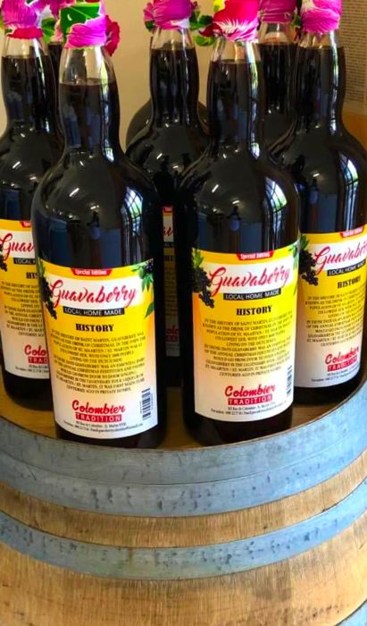 Bottles of guavaberry-infused rum elegantly displayed on a wooden barrel.