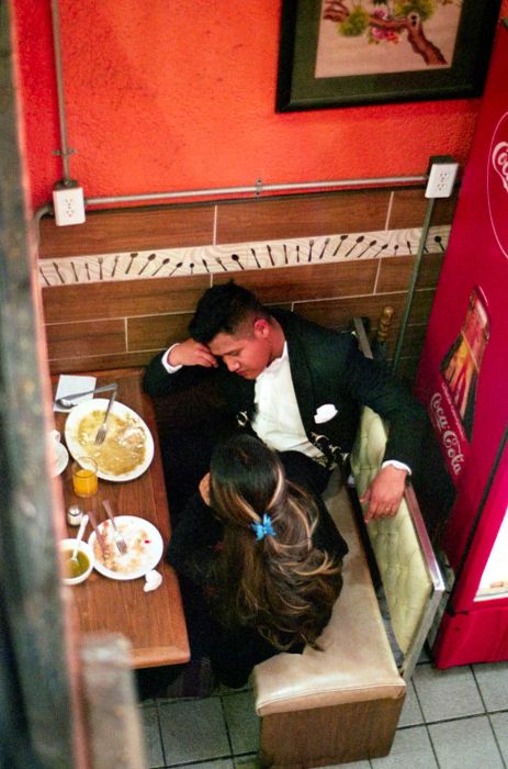 A man and woman share a close conversation in a restaurant booth.