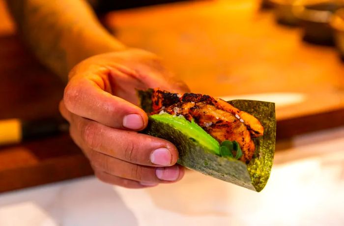 A taco wrapped in nori featuring avocado.