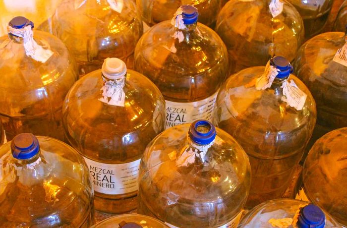 Large bottles of mezcal labeled 'Real Minero.'