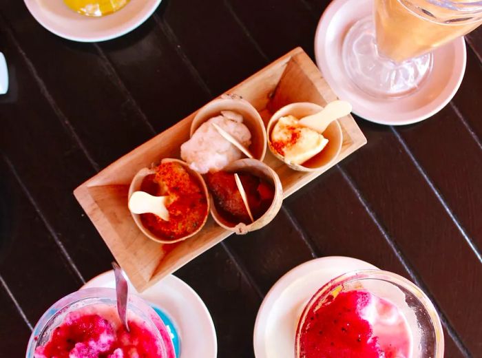 A selection of pink-topped icy treats is displayed on a table.