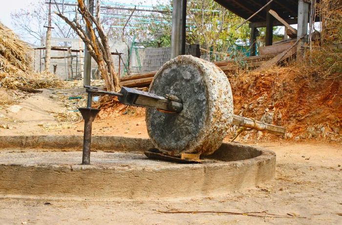 A large, weathered stone wheel.