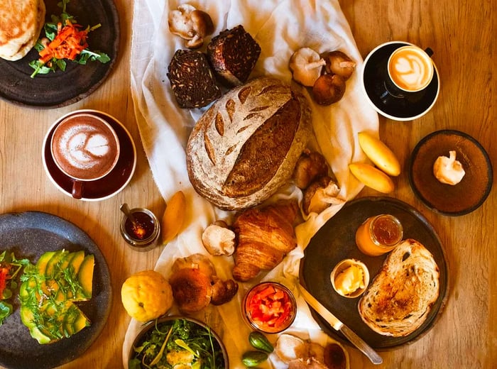 An aerial view of a table adorned with a variety of breads, toasts, and dishes.