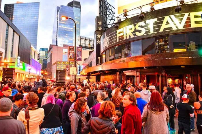 First Avenue Music Venue in Minneapolis: a crowd gathers outside the prominent venue with 'First Avenue' written in large golden letters.