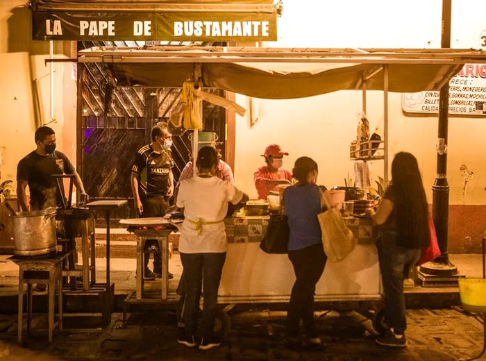 A street cart bustling with people gathered around.