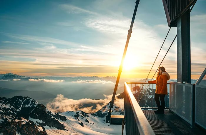 A woman gazes at the sunrise from a viewing platform at Mont Fort, Switzerland