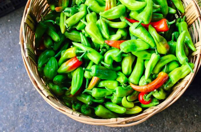 A basket brimming with fresh green chiles.