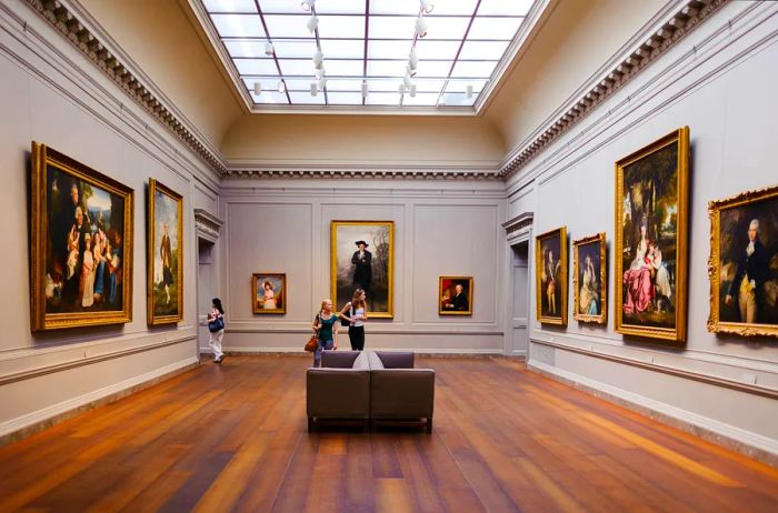 A gallery featuring large-scale portraits, all elegantly framed in gold, within an art museum.