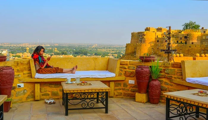 A woman savoring coffee at a rooftop café in Jaisalmer Fort.