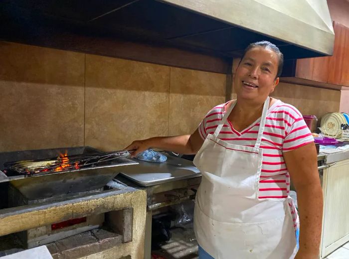 A chef oversees a flame-fired stove with care.