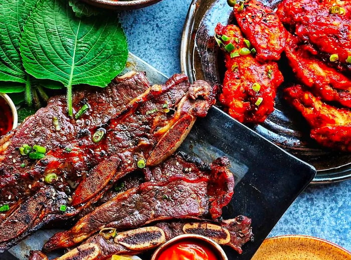 Trays showcasing an assortment of meat cuts drizzled with vibrant sauces against a textured backdrop.