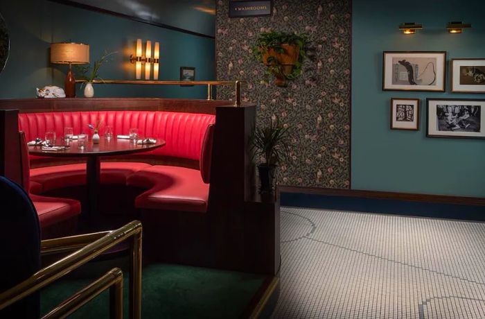 A red leather booth in a stylish midcentury-designed restaurant.