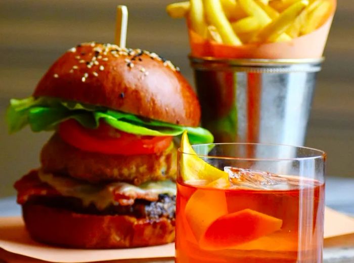 A classic burger, a Negroni, and a tin of fries.