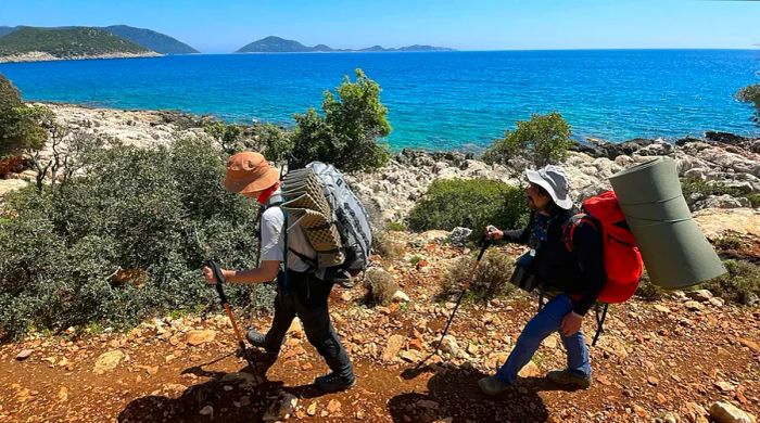 Visitors stroll along the scenic coastal hiking trail of the Lycian Way in Antalya, Türkiye.