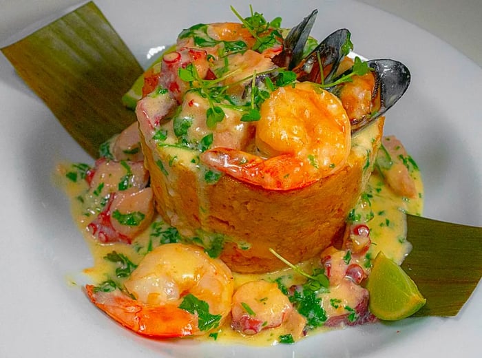 Mofongo adorned with shrimp and mussels in a luscious creamy sauce.