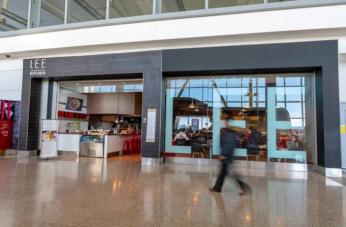 A passenger strolls past an airport restaurant.