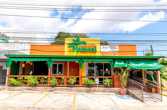 The exterior of a restaurant named El Platanal, featuring a palm tree design in place of the first L.