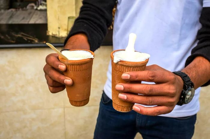 A man enjoying two cups of lassi in Jaipur, Rajasthan, India.