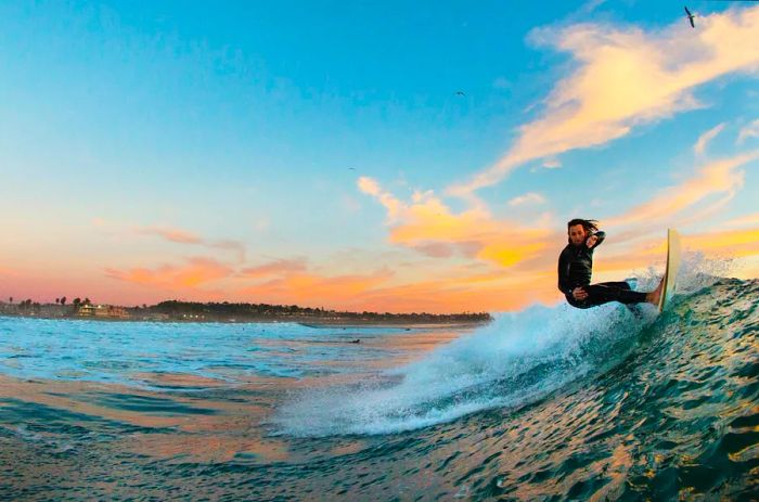 A young male surfer rides a wave at Cardiff-by-the-Sea, California, USA.