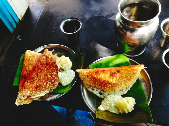 Dosas and coconut chutney elegantly presented on a banana leaf.