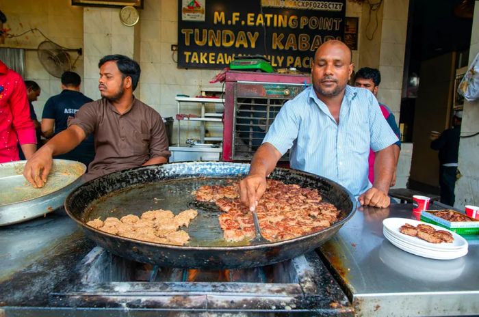 A chef frying kebabs in a traditional pan in Lucknow.