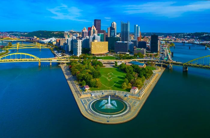 An aerial perspective of Downtown Pittsburgh showcasing Fort Duquesne and Point State Park, complete with a fountain.