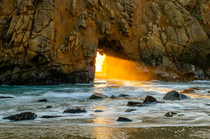 Experiencing the sunset through Keyhole Arch at Pfeiffer Beach in Big Sur, California.