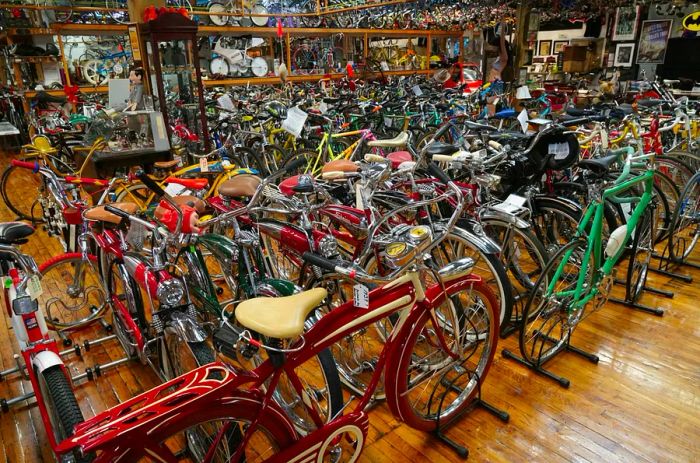 A room brimming with vintage bicycles, covering the floor and stacked on a double-decker rack