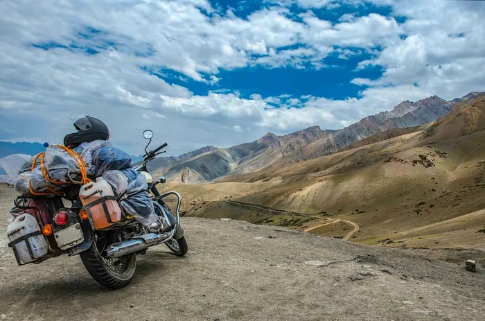 A heavily loaded motorbike navigating the rugged high-altitude mountains surrounding Leh, India