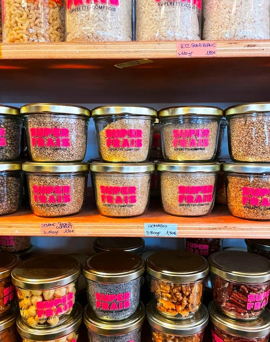 Shelves lined with jars labeled Superfrais, containing a variety of dried goods.