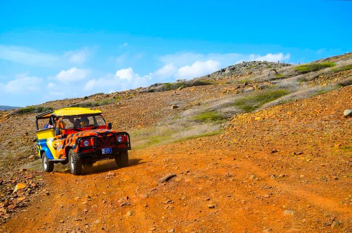 A jeep traversing the rugged terrain of Arikok National Park in Aruba.