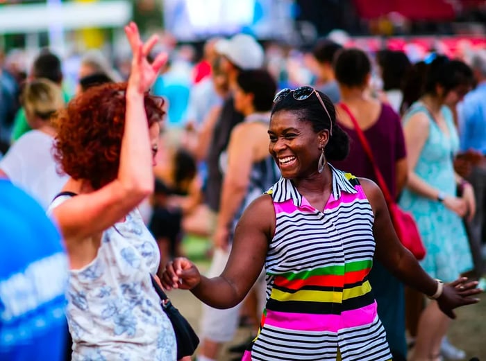 People dancing and enjoying an outdoor concert at Place des Arts in Montreal.