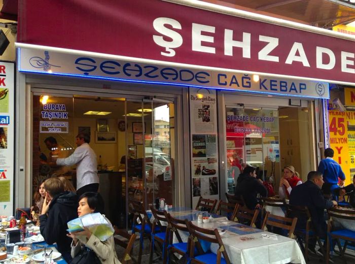 Diners enjoying their meals at tables outside an open-air restaurant.