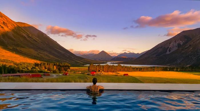 A woman gazes over the infinity pool at Flockhill luxury lodge in New Zealand