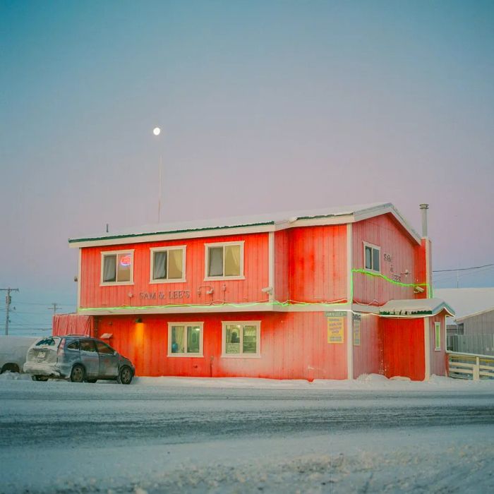 A pink building is completely enveloped in snow.