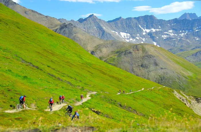 A group of mountain bikers descends a narrow trail near Mont Blanc, in the Alps, Europe.