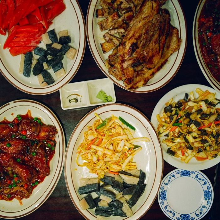 A table brimming with an array of Chinese, Korean, and American dishes awaits.