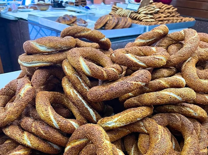 A display of round, seed-encrusted simits stacked on a counter.