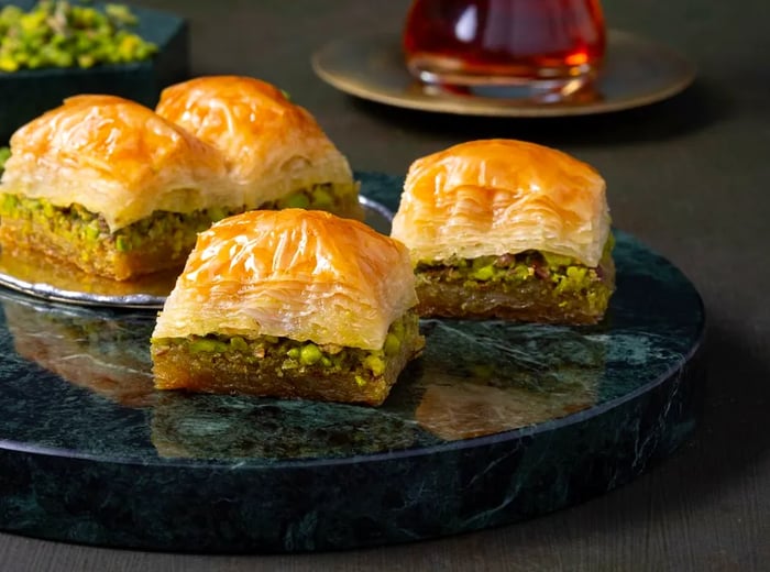 Glistening slices of baklava arranged on a shiny plate.