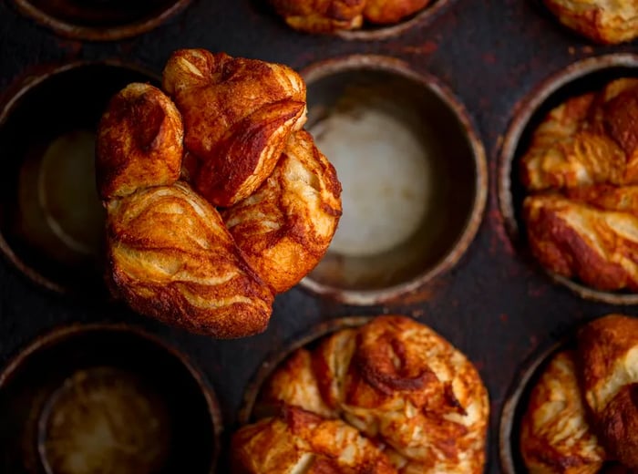 From above, kouign amann baked in dishes, with one placed on top.