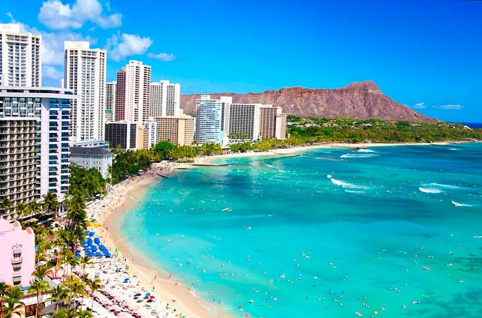 Skyscrapers line a beach where waves crash against the sandy shore.