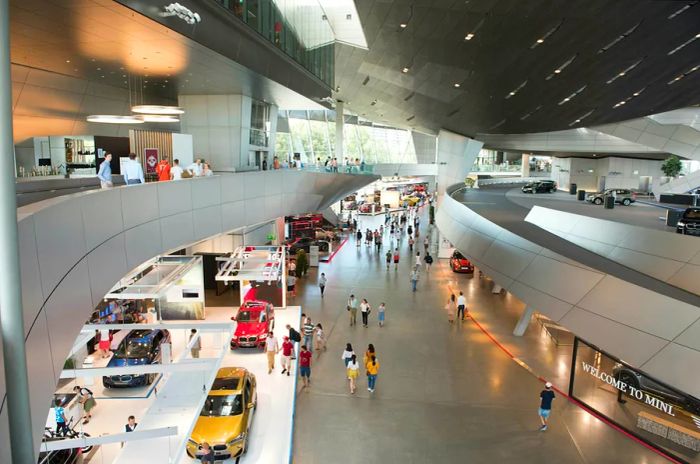 Visitors marvel at vehicles in the vast, cutting-edge galleries of BMW Welt, Munich