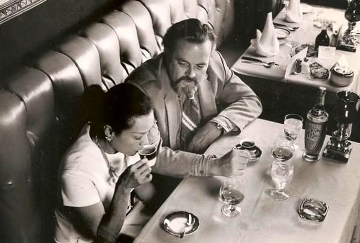 A black and white overhead photograph of a couple enjoying espresso.