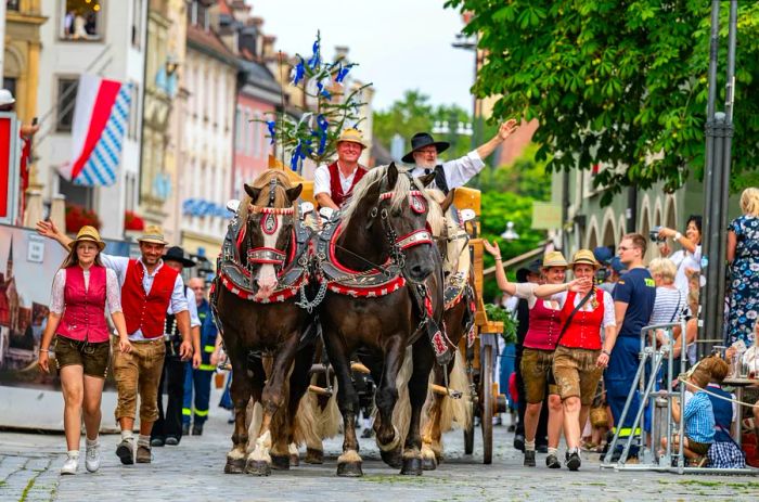 Participants donned in traditional Bavarian attire, including one on horseback, parade through the city center to inaugurate the Gäubodenvolksfest festival in Straubing, Germany.