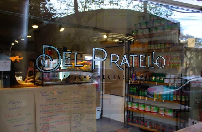 An exterior view of a shop with the name Del Pratello etched on its glass window.