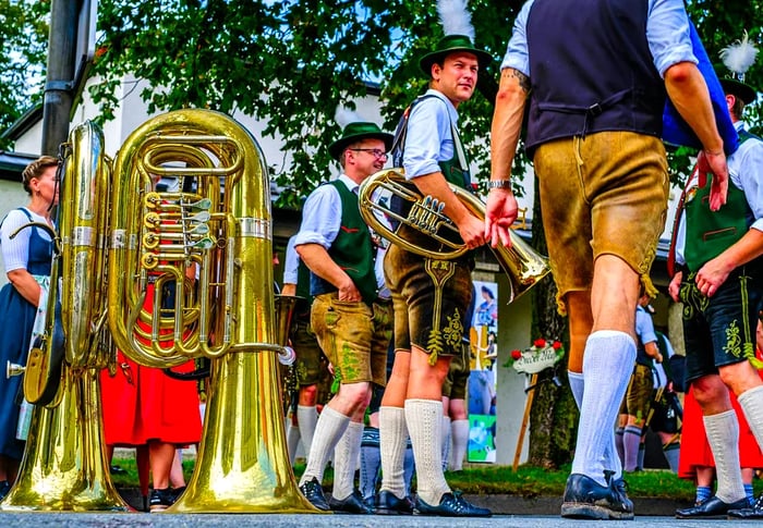 Participants dressed in lederhosen and traditional attire parade during the Herbstfest in Rosenheim, Bavaria.