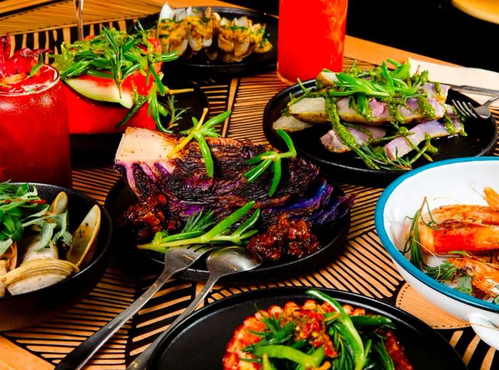 A vibrant table spread with various dishes, including quartered purple cabbage and an assortment of seafood.