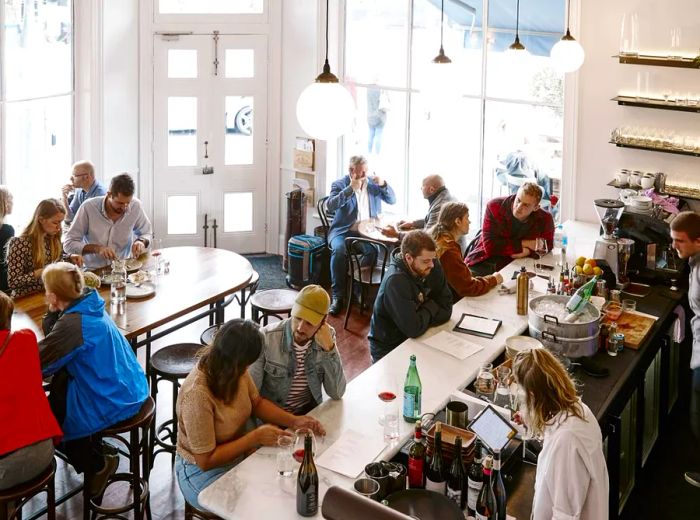 The dining area at Carlton Wine Room is bustling with patrons enjoying food and drinks.