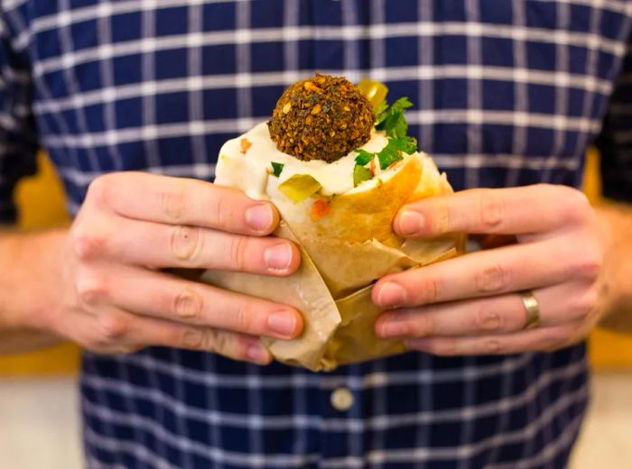 A diner enjoys a sandwich from Very Good Falafel